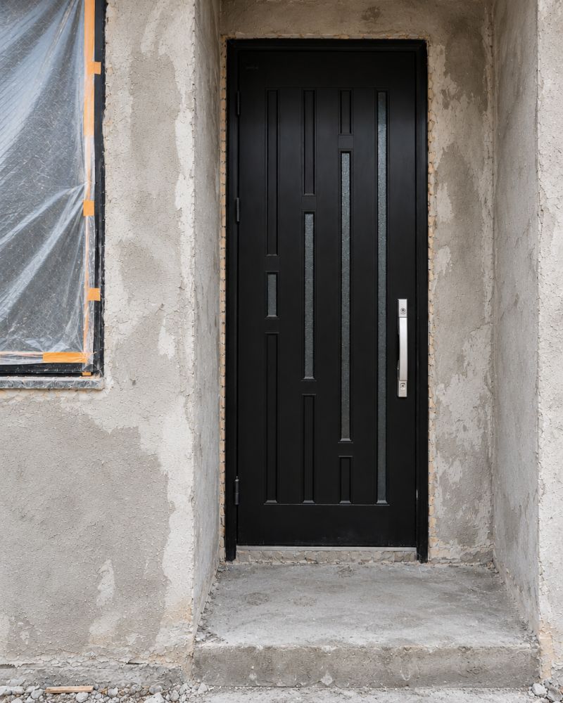 Black panelled door with glass during installation